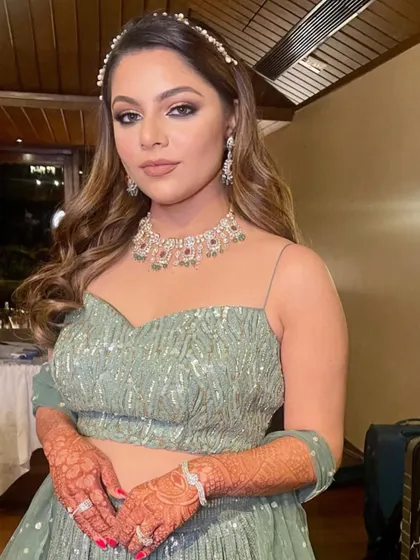 The perfect hairstyle for a sangeet or cocktail event, combining soft waves with a stylish accessory.