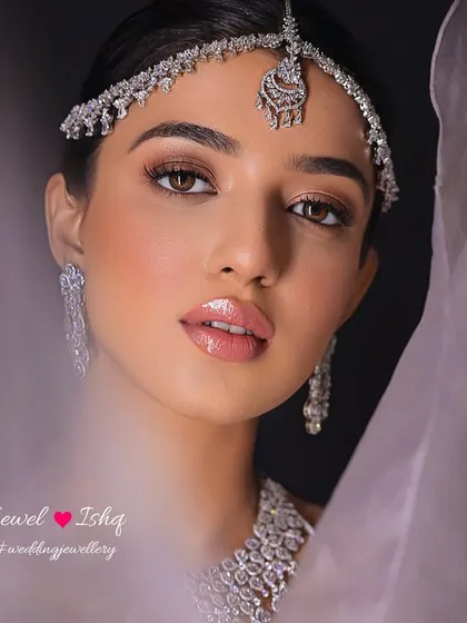 The perfect portrait of a modern bride. The focus is on the intricate diamond sheeshpatti, a contemporary take on traditional head jewellery that adds a touch of sparkle and frames the face beautifully.