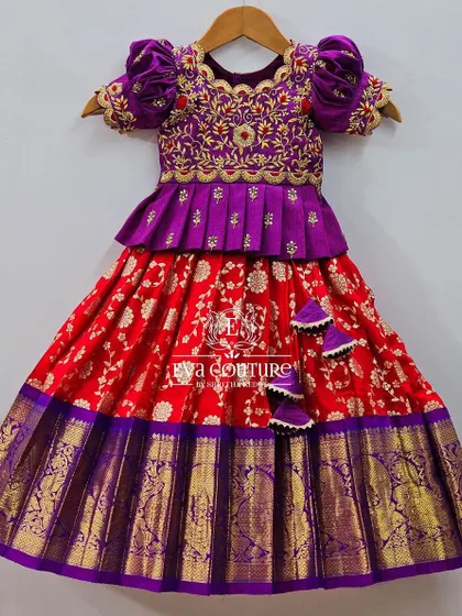 A festive Kanchi pattu lehenga in a classic red and purple combination. The purple blouse is heavily embroidered, and the red Banarasi skirt is bright and beautiful.