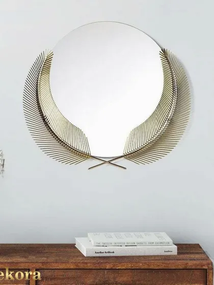 This creative wall decor mirror is framed by two elegant, feather-like metal leaves, offering a simple and sophisticated design.