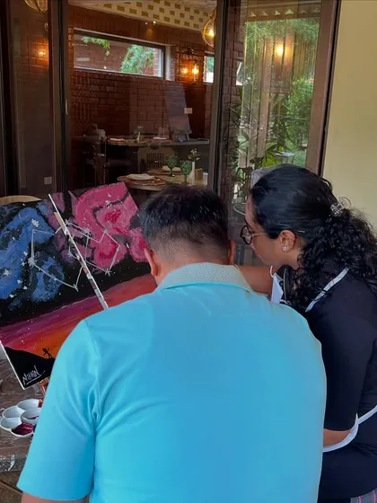 A back view of a couple working on their collaborative painting. The shared goal and creative process make for a very special date.