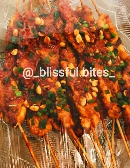 A close-up of the cooked chicken satay, showcasing the glossy sauce and fresh garnish. These skewers are a perfect blend of sweet, spicy, and savoury.