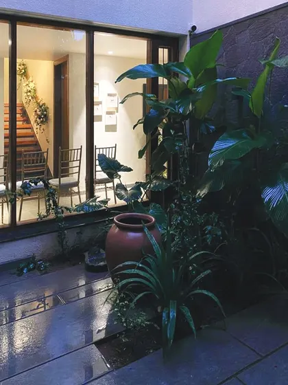 A view from the "secret garden" into the home at night. The interior lights create a warm glow, inviting you in from the cool, dark courtyard.