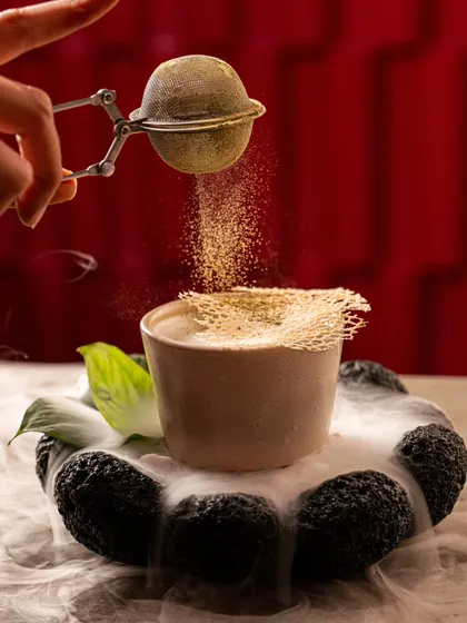 A dramatic shot of matcha powder being dusted over a dessert, with dry ice smoke creating a theatrical effect. We love adding a bit of drama to our shoots.
