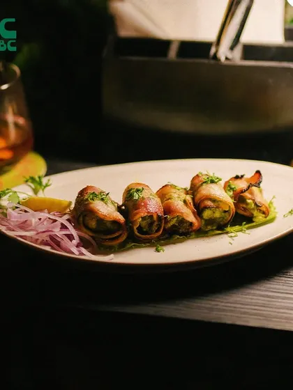 A plate of delicious bacon-wrapped appetizers, perfectly grilled and ready to be enjoyed with your favorite drink.