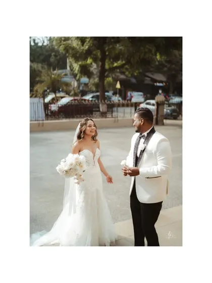 The bride and groom sharing a happy, candid moment outside the church. Their smiles and interaction create a natural and joyful portrait.