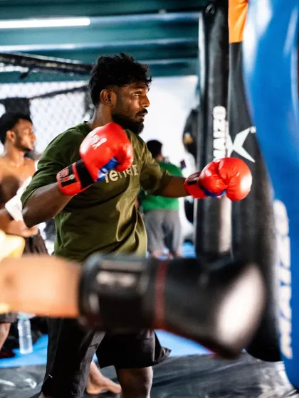 A student working the heavy bag, a classic and essential tool for developing punching power and endurance. The path to victory is paved with sweat.