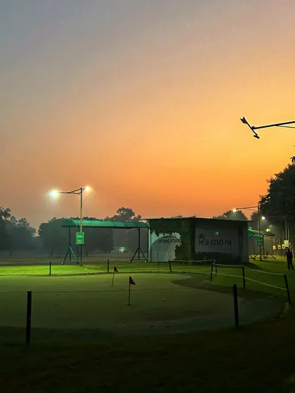 The putting green and fitting studio bathed in the warm colors of a beautiful sunset.