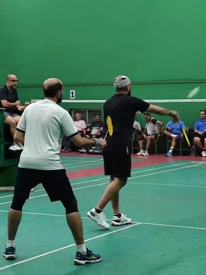 An action shot from one of the doubles matches, with a player about to hit a backhand shot.