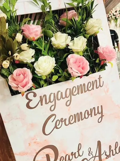 A close-up of a modern and elegant welcome sign for Pearl and Ashley's engagement ceremony. The pink marble texture is complemented by a 3D floral arrangement, creating a chic and stylish first impression.