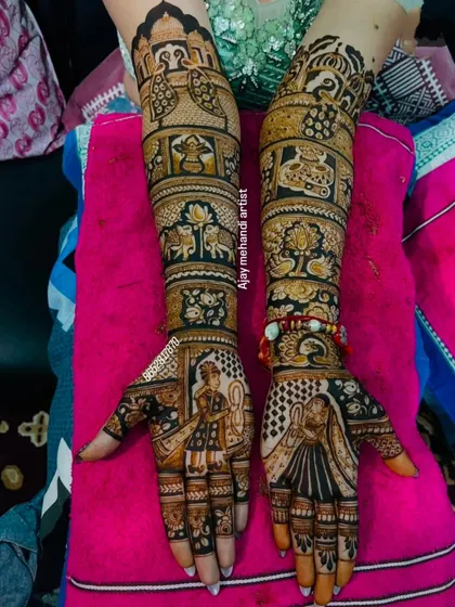 This design combines portraits with traditional motifs. The palms feature the bride and groom, while the arms are adorned with peacocks, elephants, and lotus flowers.