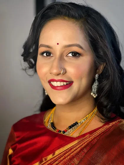A smiling portrait that shows how a classic red lip and soft glam eyes can create a look that is both timeless and full of personality.