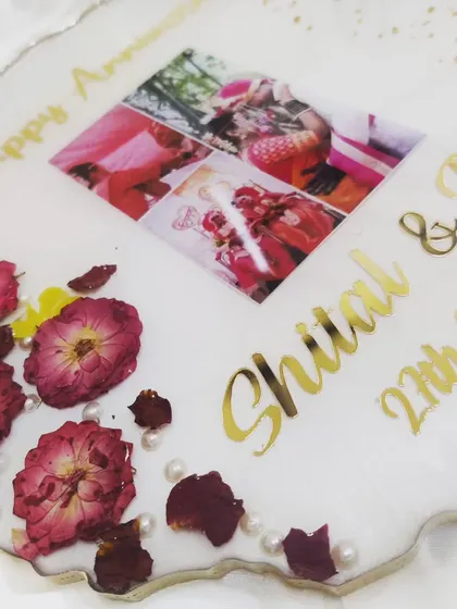 A close-up view of the anniversary platter, showing the clear resin and the vibrant colors of the preserved rose petals against the white base.