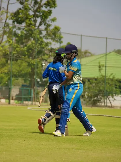 A moment of camaraderie between two partners after a run, embodying the spirit of teamwork in cricket.