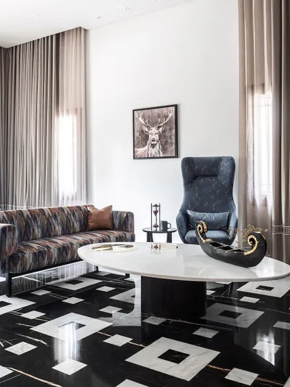 For the large office space, we shifted to a contemporary yet timeless aesthetic. Exotic black and white marble flooring in an overlapping pattern and plush, modern furniture create an elegance befitting the many different people this space would host.