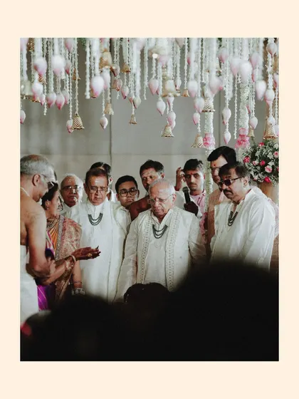 A candid shot of the elder male members of the family participating in the ceremony.