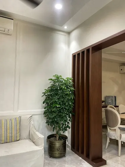 A beautiful Ficus plant in a handcrafted antique brass planter. This combination adds a touch of vintage elegance and warmth to this cozy living room corner.