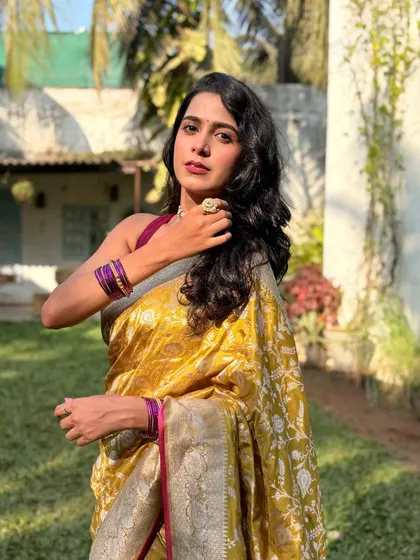 Actress Jui Bhagwat looking radiant in a yellow Banarasi saree for the "Gudhi Shubhrambhachi" music video. The makeup is fresh and sun-kissed.