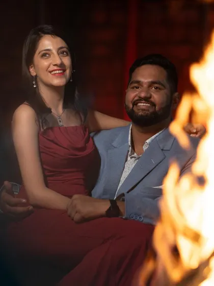 The couple sharing a happy moment. Both have camera-ready makeup that looks fantastic in this warm, intimate lighting.