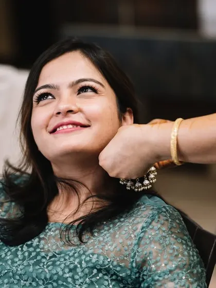 A friend helping the bride with her hair. During mehendi, the bride's friends and family are there to help with everything.