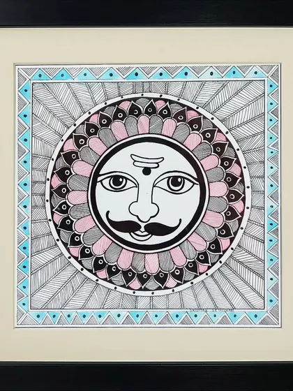 The sun god, Surya, is depicted in the classic Madhubani style by artist Lakshit Mukhiya. The face is surrounded by intricate patterns, representing the sun's powerful rays.