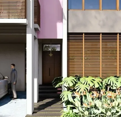 A close-up view of a villa entrance, highlighting the interplay of textures between the smooth concrete, warm wooden louvers, and lush monstera plants.