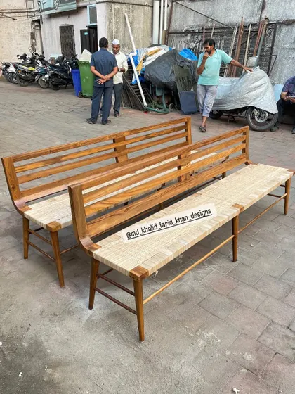 A closer view of the benches, showing the detail of the woven seating and the sturdy wooden frame with a backrest.