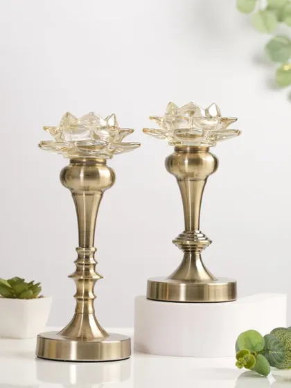 A pair of antique-finish brass candle holders with a lotus design, perfect for traditional yet elegant Diwali decor.