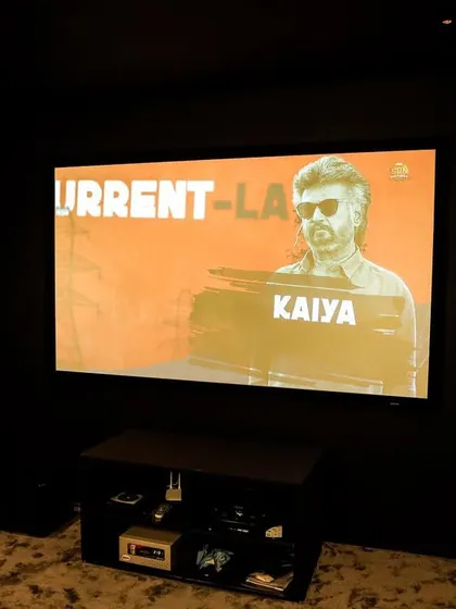 The large screen displays a movie with incredible clarity, thanks to the 4K projector and the dark, non-reflective walls of the room.
