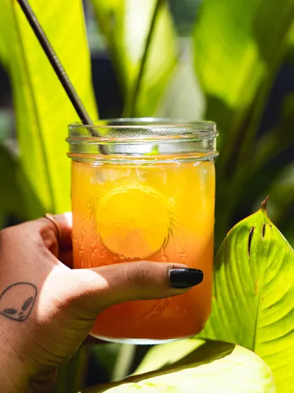 A vibrant orange-colored mocktail, another one of our refreshing summer creations.