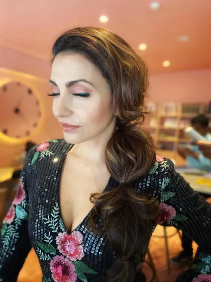 A beautiful shot showcasing the soft pink eye makeup and the texture of the messy side braid.