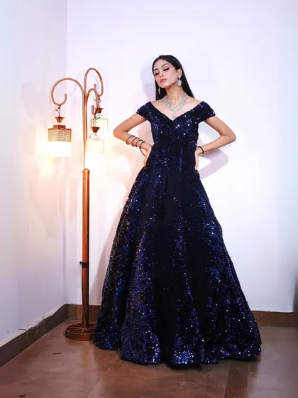Posing in the midnight blue sequin gown, which features a flattering A-line silhouette that suits all body types.