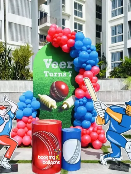 We hit a six with this cricket theme for Veer's first birthday. The outdoor setup featured a pitch-green backdrop, cutouts of a batsman and bowler, and a balloon arch in the team colors of red and blue.