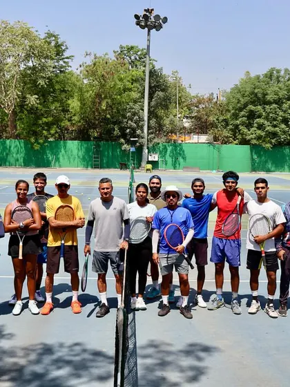 A group of our dedicated players and coaches gathered on the court. This photo represents the strong sense of community and shared purpose that defines our "Tennis-a-Holic Family".