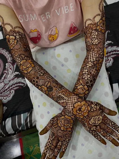 This bridal floral design covers the arms completely, creating a stunning sleeve of henna art for the bride's special day.