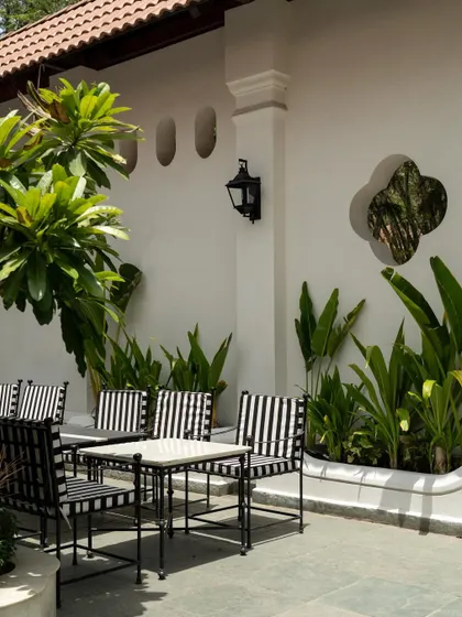 Views of the courtyard at Elgin Cafe, a space designed for pause and reflection. I used white lime-washed walls, lush tropical plants, and classic lantern-style lighting to create an intimate, serene outdoor dining experience.