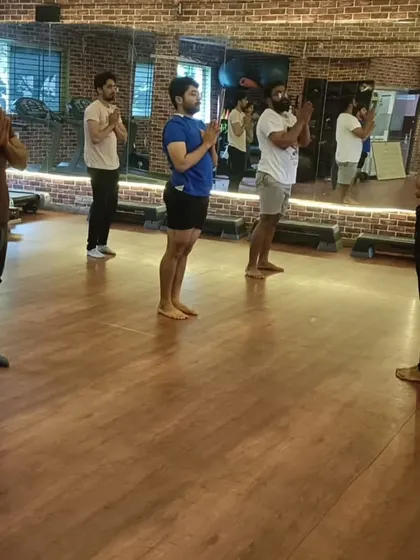 The entire class joins in the opening Pranamasana, creating a shared sense of purpose for the session ahead.