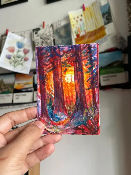 Holding up my tiny, vibrant forest painting. It's a small world of imagination that I can hold in my hand.