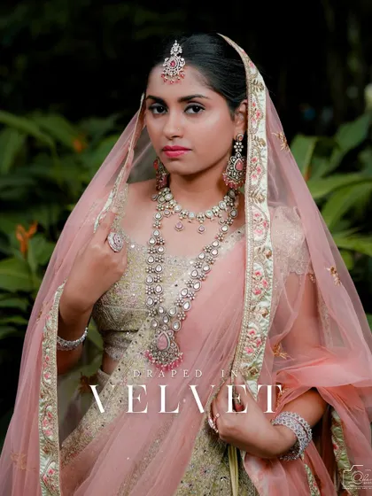 This bride is draped in elegance, wearing a full Victorian-Polki set with pastel pink stones that perfectly complements her lehenga.