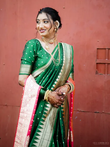 The joy of a bride in her traditional attire. Her smile is radiant, and the classic makeup look enhances her features beautifully against the rich colors of her saree.
