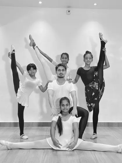 A powerful group photo of me with my ballet students, all demonstrating incredible flexibility with standing splits and a full center split.