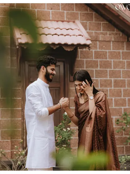 A shy, happy glance from the bride-to-be, framed by leaves, adding a natural and intimate feel to this pre-wedding photo.
