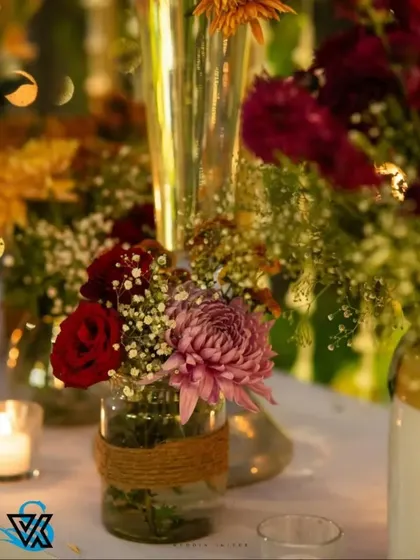 The same jute-wrapped jars look magical in the evening, with the soft glow of a nearby candle illuminating the colorful flowers.