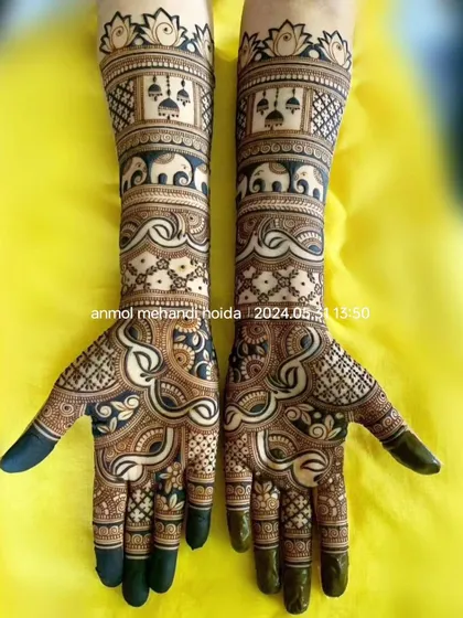 This design features bands of marching elephants and hanging jhumkas, creating a festive and royal look. The fingertips are fully covered in henna for that deep, rich bridal stain.
