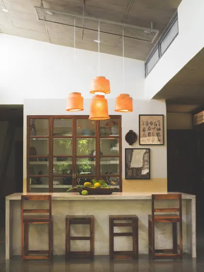 The kitchen island and upcycled pantry cabinet at 'Aamra'. This view shows how the kitchen is designed as the home's central hub, a place for both cooking and gathering, with custom furniture that blends service and served spaces.