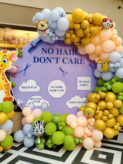 Photo booths add so much fun to a party. For this "No Hair, Don't Care" Mundan celebration, I created a playful backdrop with a large circular sign, cute graphics, and a colorful balloon garland, giving guests a fun spot to capture memories.