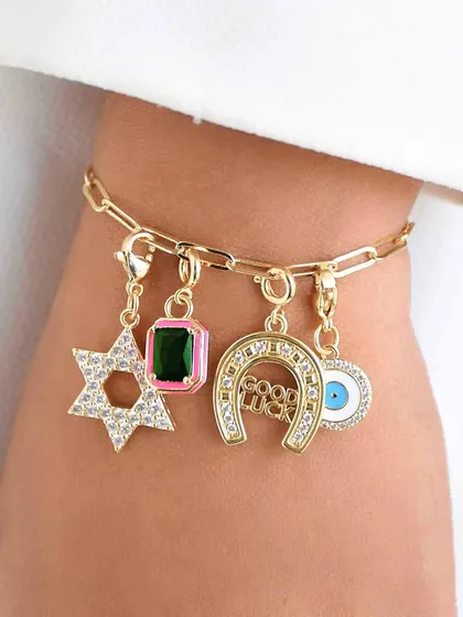 A bracelet that brings all the luck. This piece combines a Star of David, a gemstone charm, a horseshoe, and an evil eye for a powerful and personal statement.
