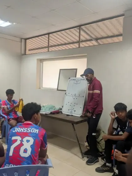 A coach delivering a tactical talk on a whiteboard in the dressing room during the AIFF U17 Elite Youth League.
