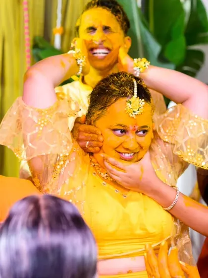 The bride can't escape. Neha's friends and family make sure she gets her fair share of haldi in this fun, chaotic shot.