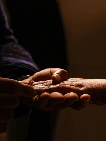 A close-up of the ring exchange, silhouetted to create a dramatic and symbolic image.